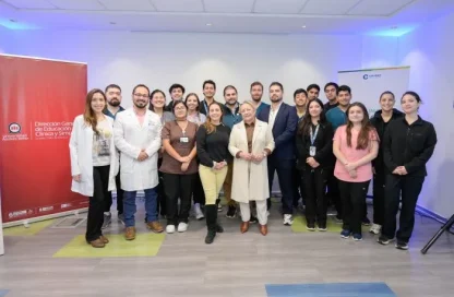Group of healthcare and education professionals posing for a photo in a seminar room with banners on the sides.