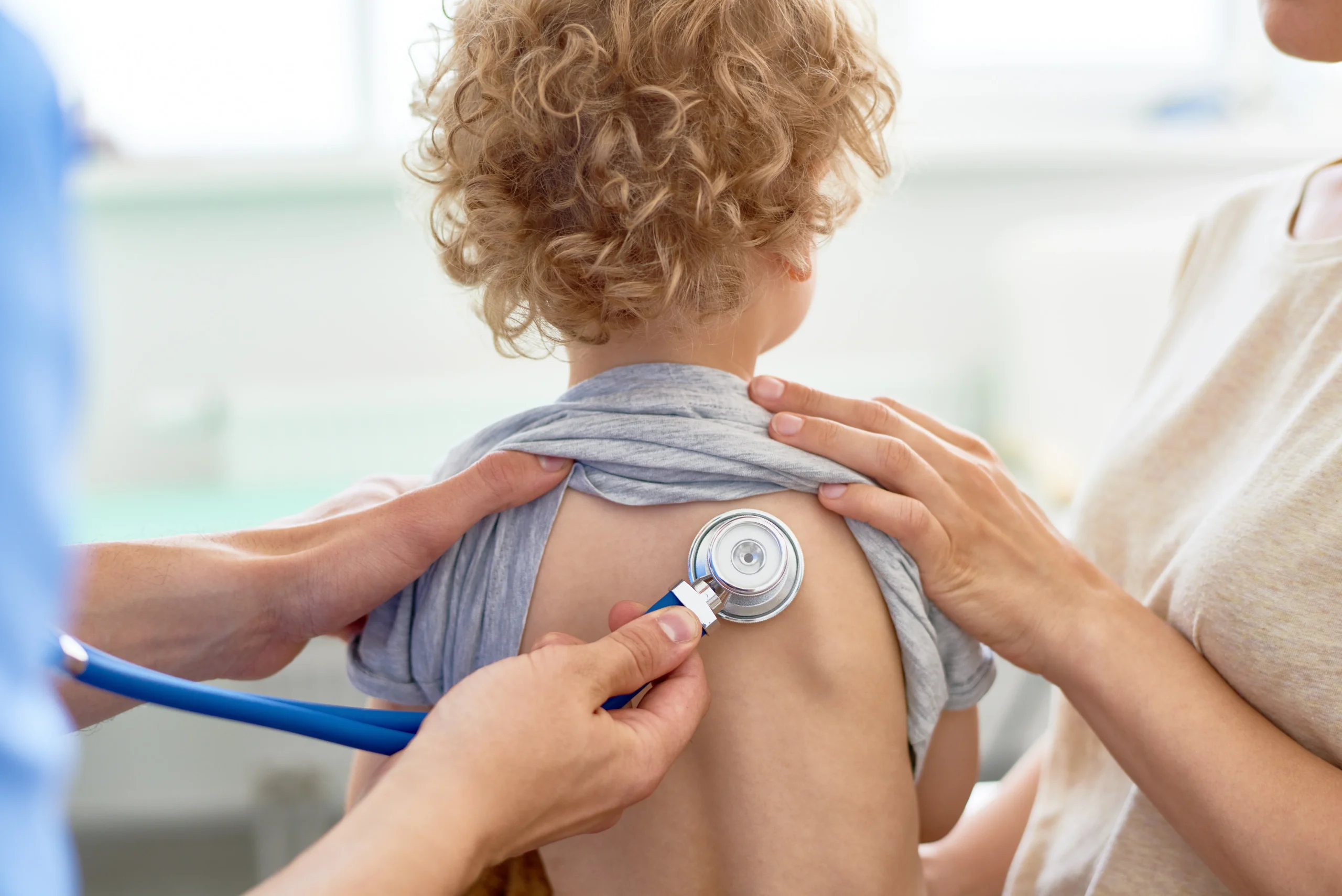 Child being examined by a doctor; stethoscope placed on the child's back during a medical checkup