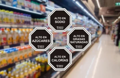 Four octagonal health warnings floating over a grocery store aisle: Alto en sodio, Alto en azúcares, Alto en grasas saturadas, Alto en calorías (Ministerio de Salud).